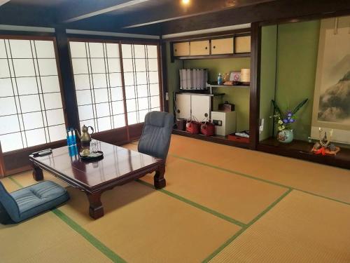 a living room with a table and a chair at Hitsujipotchi-Kyoto in Yatsuai