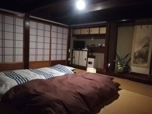 a bedroom with a large bed in a room at Hitsujipotchi-Kyoto in Yatsuai
