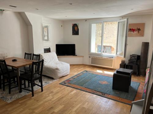 un salon avec une table et un canapé dans l'établissement Appartement , terrasse tropezienne proche Cascade de la Vis, à Saint-Laurent-le-Minier