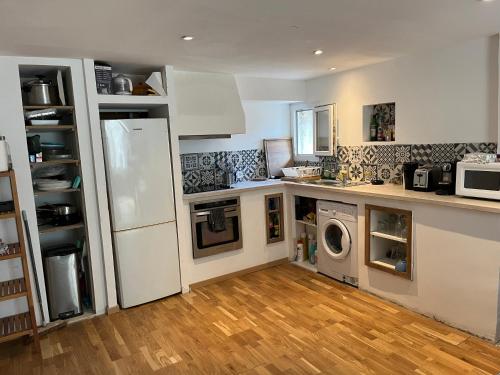 Il comprend une cuisine équipée d'un réfrigérateur et d'un lave-linge/sèche-linge. dans l'établissement Appartement , terrasse tropezienne proche Cascade de la Vis, à Saint-Laurent-le-Minier