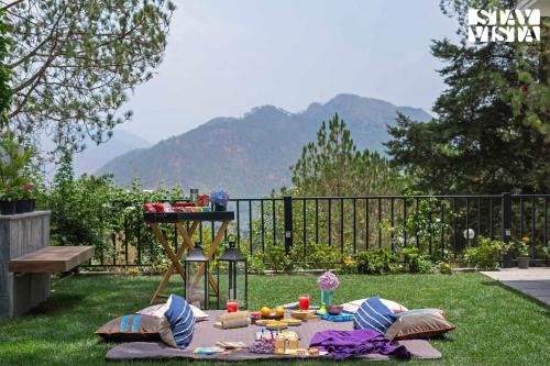 Un picnic montado en el césped del patio. en StayVista at Kaira with Music Speaker & Heater, en Bhowāli