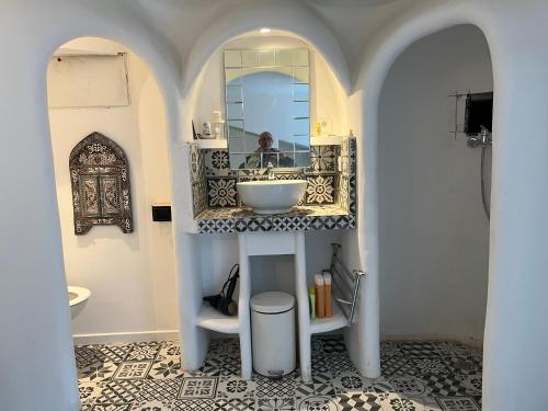 une salle de bain avec un lavabo et un miroir dans l'établissement Appartement , terrasse tropezienne proche Cascade de la Vis, à Saint-Laurent-le-Minier