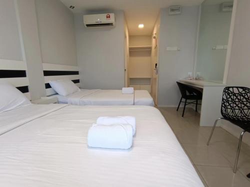 Ένα ή περισσότερα κρεβάτια σε δωμάτιο στο LEA GUEST HOUSE & CAFE Lukut