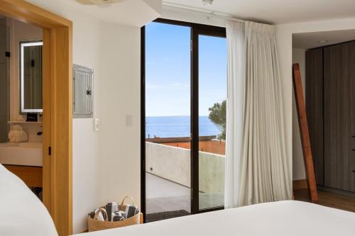 ein Schlafzimmer mit Bett und Blick auf das Meer in der Unterkunft Malibu Sand Carbon Beach Suites in Malibu