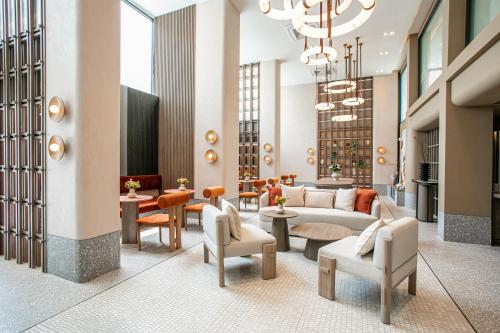 a lobby with a couch and chairs and tables at Pillow B Hotel in Ban Zong Katiam