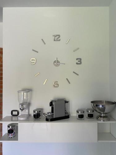 a clock on a wall above a counter with a appliance at La Canonica di Soglio in Camerano Casasco