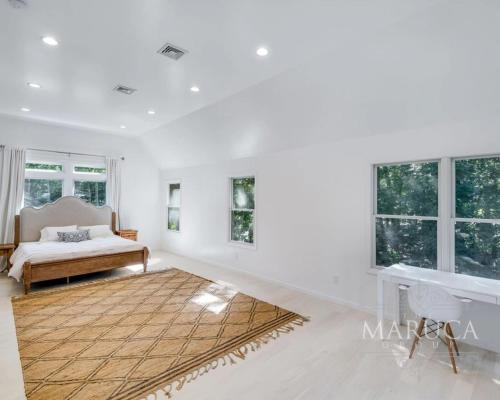 a white living room with a bed and windows at Villa KeyLime in Sag Harbor