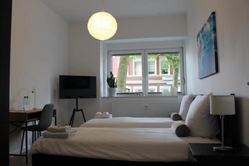 a bedroom with a bed and a window and a television at Zimmer mitten in der Stadt 400 Meter zum Bahnhof in Paderborn