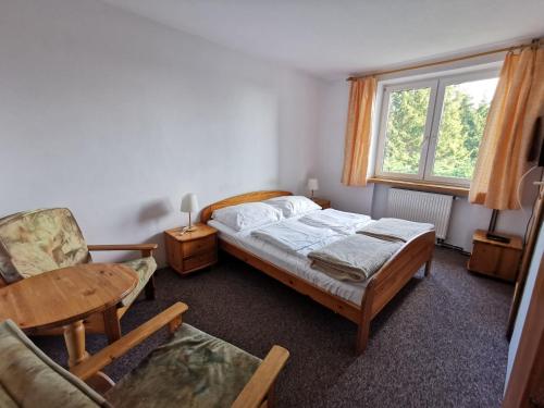 a bedroom with a bed and a table and a chair at Ośrodek Wypoczynkowy "U Kulasa" in Warchały