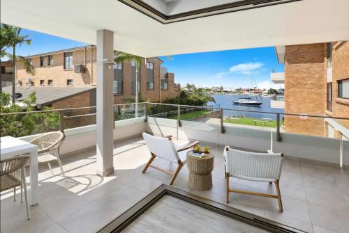 a balcony with white furniture and a view of the water at Luxury 2 Bedroom Unit Mooloolaba in Mooloolaba