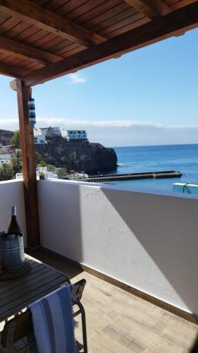 a balcony with a table and a view of the ocean at Poril in Gran Tarajal