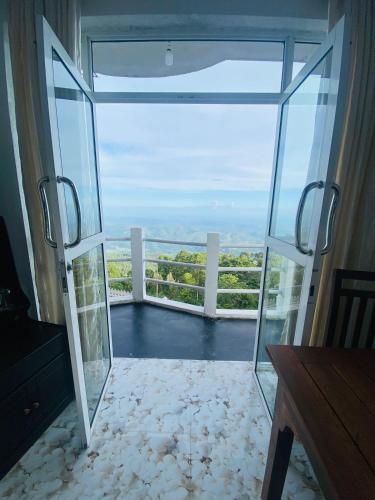 an open glass door with a view of the ocean at Grand Glorious in Haputale