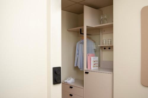 a room with a closet with a dresser and a shirt at Bob W Turku City Centre in Turku