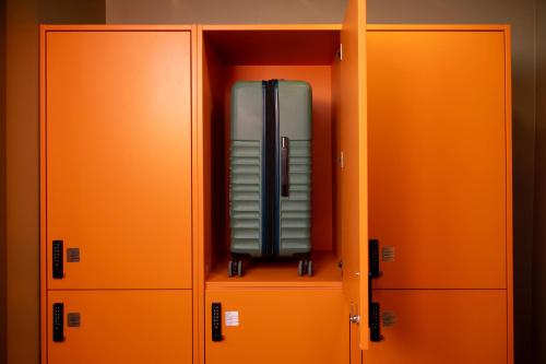 a briefcase is sitting inside of an orange cabinet at Bob W Turku City Centre in Turku