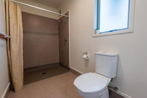 a bathroom with a toilet and a shower at Tasman Holiday Parks - Coromandel in Coromandel Town