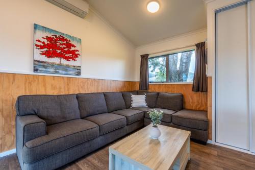 a living room with a couch and a coffee table at Tasman Holiday Parks - Coromandel in Coromandel Town