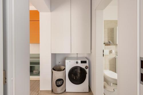 a bathroom with a washing machine and a toilet at A&A Luxury Apartment in Giroc