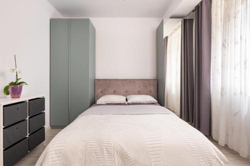 a bedroom with a large bed and a window at A&A Luxury Apartment in Giroc