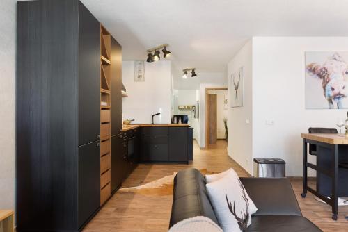 a living room with a couch and a kitchen at Albchalet in Rosenfeld