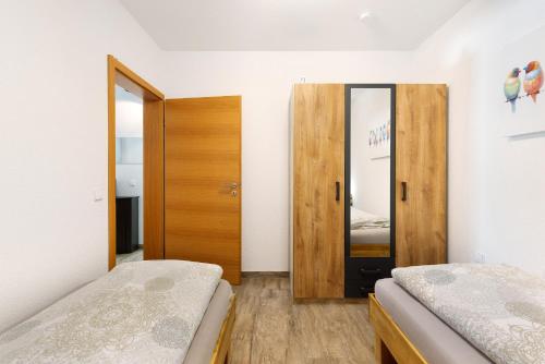 a bedroom with two beds and a wooden door at Albchalet in Rosenfeld