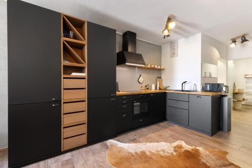 a kitchen with black cabinets and a large black refrigerator at Albchalet in Rosenfeld