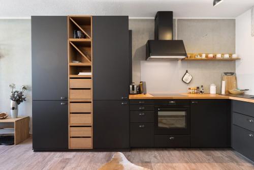 a kitchen with black cabinets and a stove at Albchalet in Rosenfeld