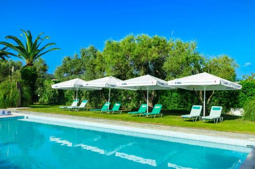 a group of chairs and umbrellas next to a swimming pool at Hotel Hanioti Village Spa in Hanioti