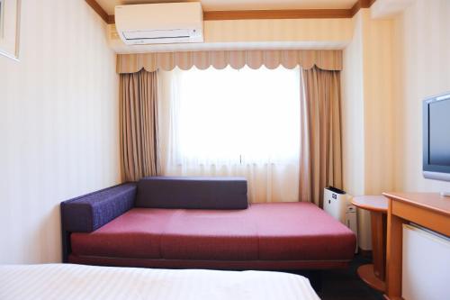 a small room with a red couch and a window at Hotel Castle Inn Ise Meotoiwa in Ise