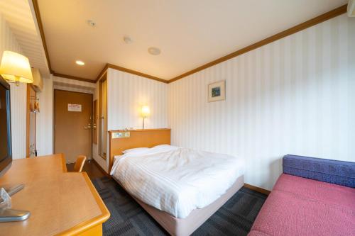 a bedroom with a bed and a table and a desk at Hotel Castle Inn Ise Meotoiwa in Ise