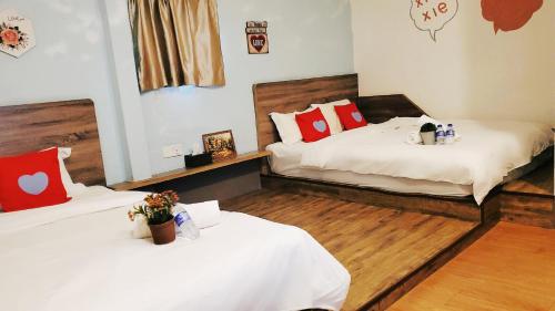 two beds in a room with wooden floors at Winggarden Murals House by JE Boutique Guesthouse in Ipoh