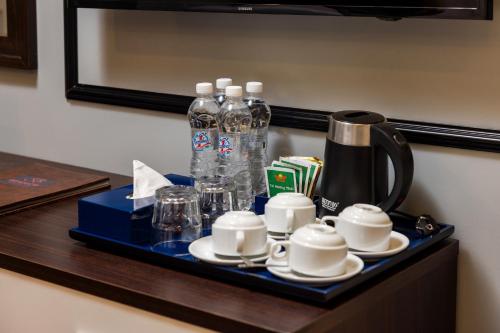 a tray with coffee cups and bottles on a table at Bendecir Hotel & Spa in Hanoi