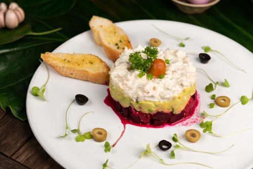 a white plate with a piece of cake and bread at The Jungle in Siem Reap