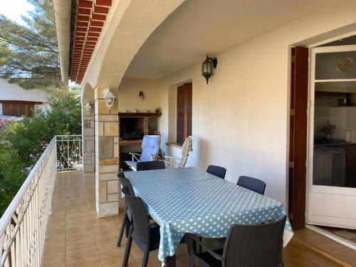 un patio avec une table et des chaises sur un balcon dans l'établissement Villa proche Anse Magaud, à La Garde