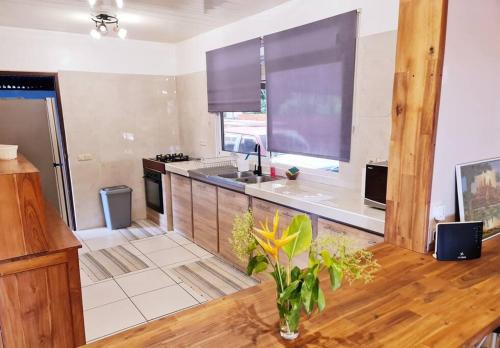 a kitchen with a vase of flowers on a wooden table at Maison du bonheur Moorea in Vairoa