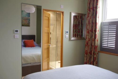 a bedroom with a bed and a door with a window at Stylish Garden Apartment, Exmouth - 'Little Monty' in Exmouth