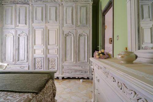 a room with white cabinets and a table with a vase at Il posto del cuore in Brindisi