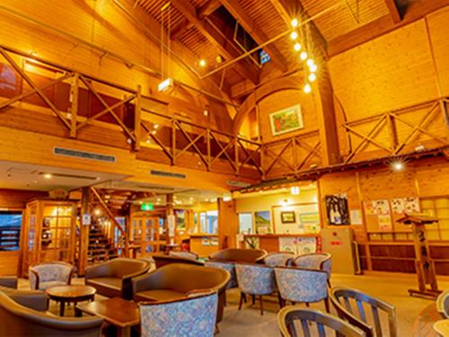 a restaurant with tables and chairs in a room at Miyama Nature and Culture Village Kajikaso in Nakamura