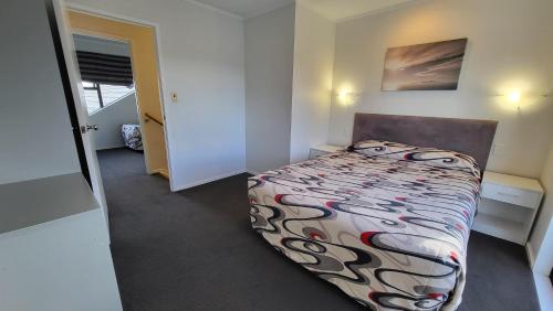 a small bedroom with a bed in a room at Manukau Motor Lodge in Auckland