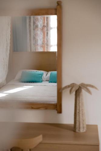 a bedroom with a mirror and a bed with blue pillows at Opera House Hotel in Symi