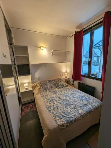 une petite chambre avec un lit et une fenêtre dans l'établissement Studio du Phare Berck Plage, à Berck-sur-Mer