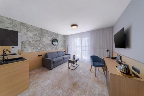 a living room with a couch and a television in a room at Hotel Senec Aqua Resort - Family friendly in Senec