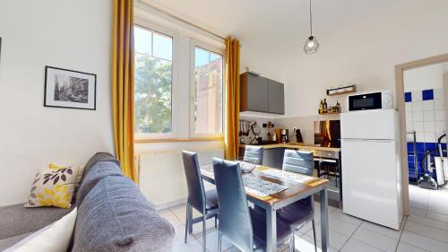 un salon avec un canapé et une table et une cuisine dans l'établissement La Suite Barberousse - Éclats Bleus et Dorés, à Wittenheim