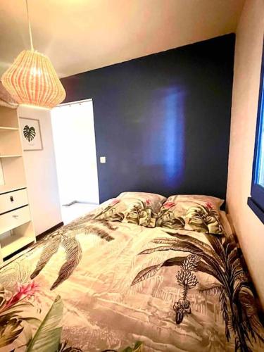 une chambre avec un lit et un mur bleu dans l'établissement Baie D'Azur Vue Mer Piscine Parking, à Villeneuve-Loubet