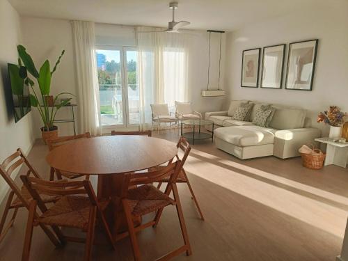una sala de estar con una mesa y un sofá en Nasila Beach & Golf, en Motril