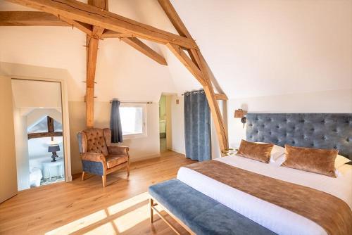 une chambre avec un grand lit et une chaise dans l'établissement Hotel Haras De La Potardiere, à Crosmières