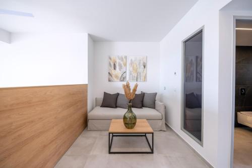 a living room with a couch and a table at Thimios Suites Adults Only in Acharavi