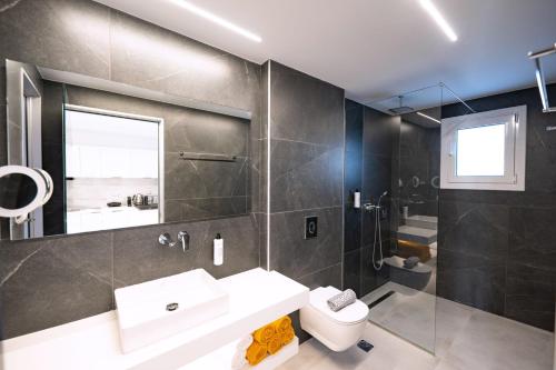 a bathroom with a sink and a toilet at Thimios Suites Adults Only in Acharavi