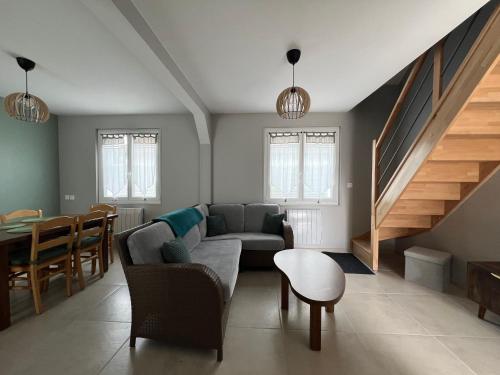 a living room with a couch and a table at Le Charles Pierre in La Ferté-Saint-Aubin