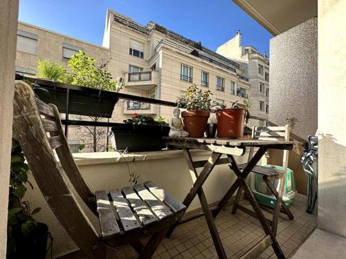 d'un balcon avec une table et des plantes en pot. dans l'établissement Appartement lumineux avec balcon, à Levallois-Perret