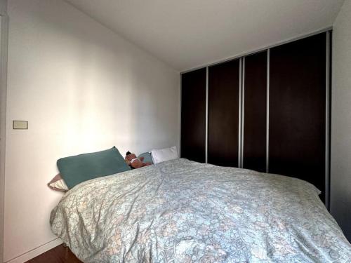 - une chambre avec un grand lit et un oreiller vert dans l'établissement Appartement lumineux avec balcon, à Levallois-Perret